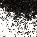 Black coarse-grained sand scattered on white surface, Black Sand product
