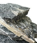 Stacked black slate stone with dark gray rocks, white speckles, jagged edges