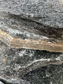 Black slate stone with rough dark gray surface and brownish speckled edge