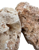 Hole stone product featuring two weathered porous rocks with rough texture in beige tan and light brown tones
